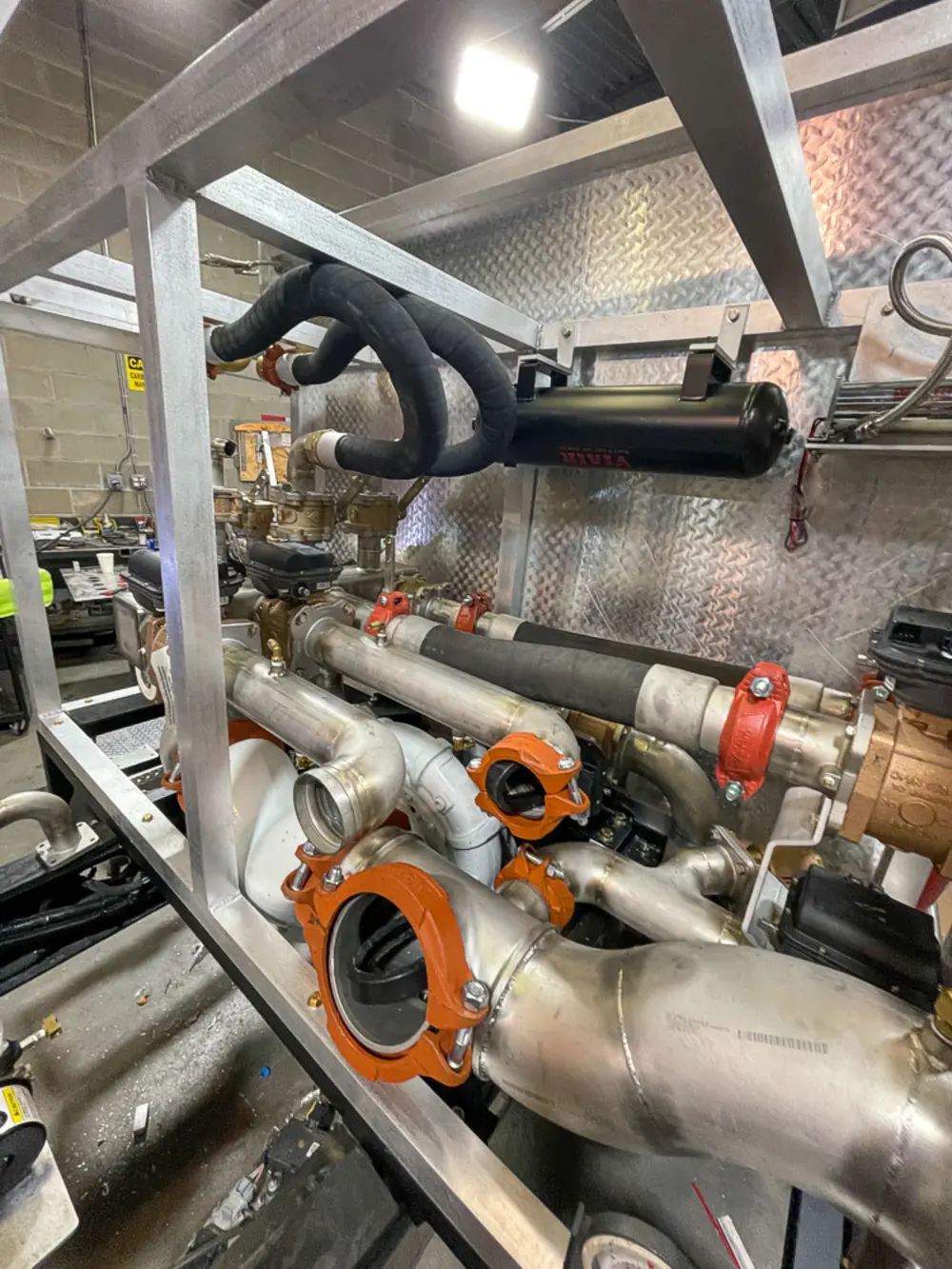 Exterior view of small fire truck showing cab, body compartments, and wheel/tire area.